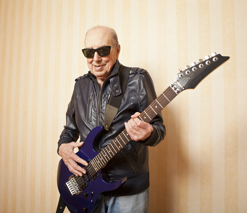 An elderly man holding guitar. Image from Shutterstock.com